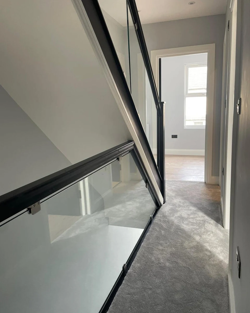 staircase-glass-balustrade-black-handrail-landing-reigate-reigate-glass-balustrades Glass balustrade with satin black handrail on upper landing, Reigate