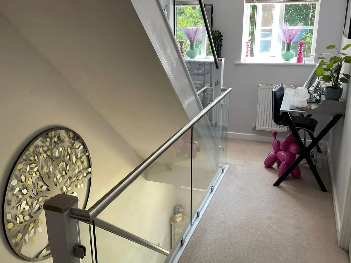 Frameless glass balustrade with white newel posts on landing, Reigate Glass Balustrades